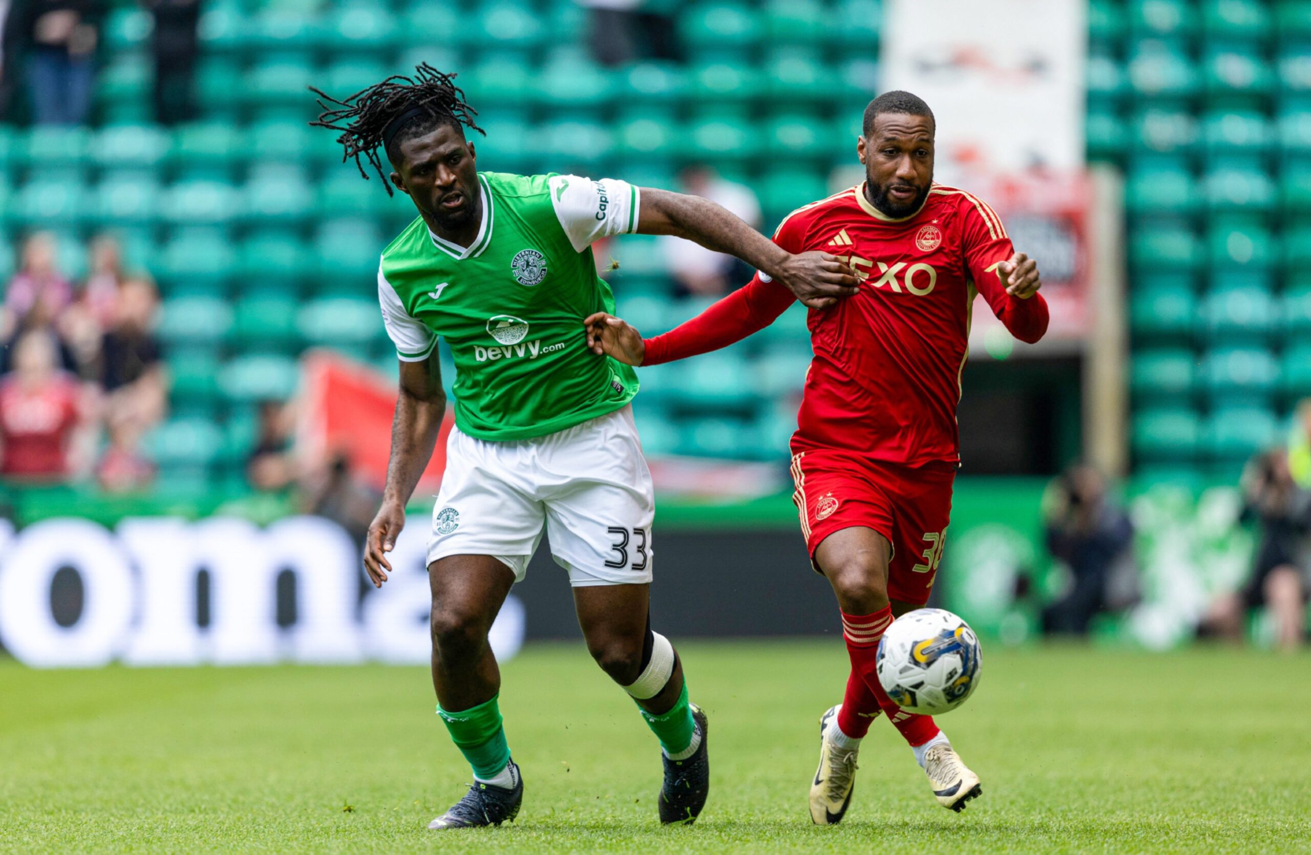  Hibernian's Rocky Bushiri and Aberdeen's Junior Hoilett in action . Image: SNS 