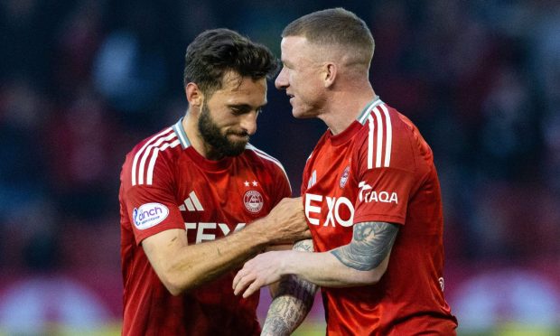 Aberdeen's Graeme Shinnie gives Jonny Hayes the armband during the win against Livingston. Image: SNS.