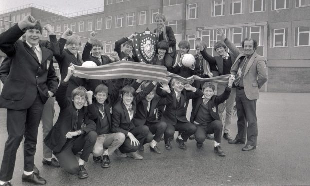 1983: The triumphant Kincorth under-14 team captain Mike Craig holds aloft the Scottish Schools Under-14 Shield at the school. Image: DC Thomson