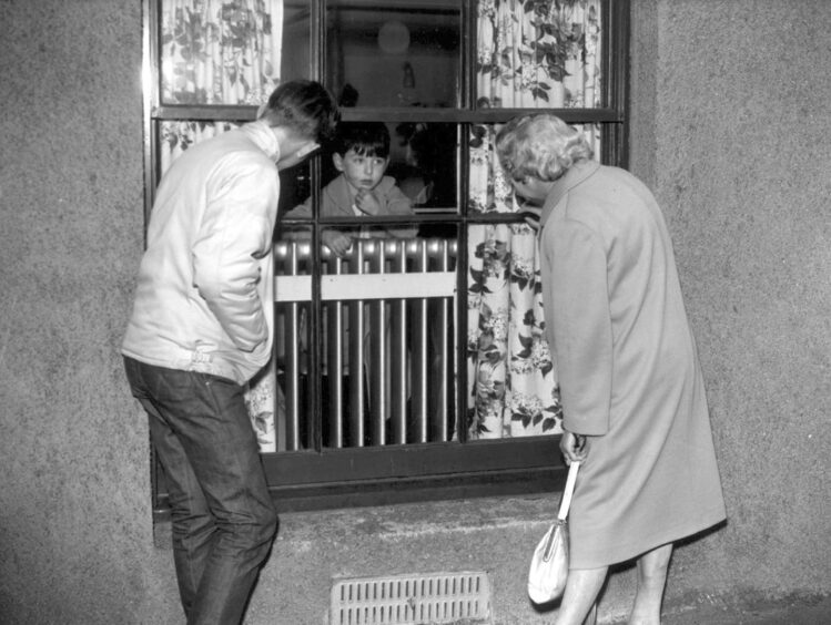 A small boy, victim of typhoid, talking to his granny through the hospital window in Aberdeen during the outbreak.