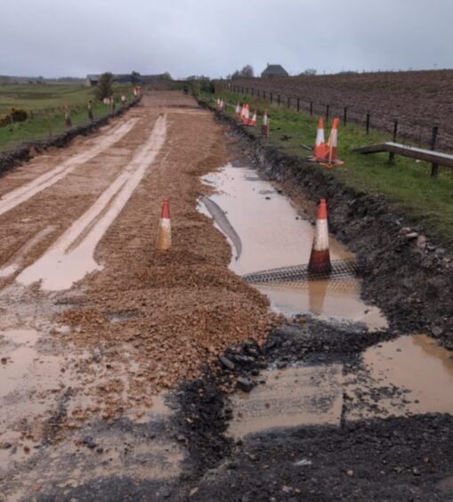 The A96 turns to brown due to mud and puddles following heavy rain showers.
