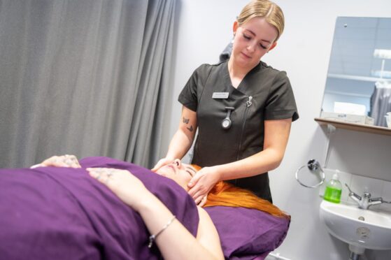 an integrative healthcare degree student massages the head of a person who's lying down. UHI Moray's integrative healthcare degree is one of the healthcare courses in UK