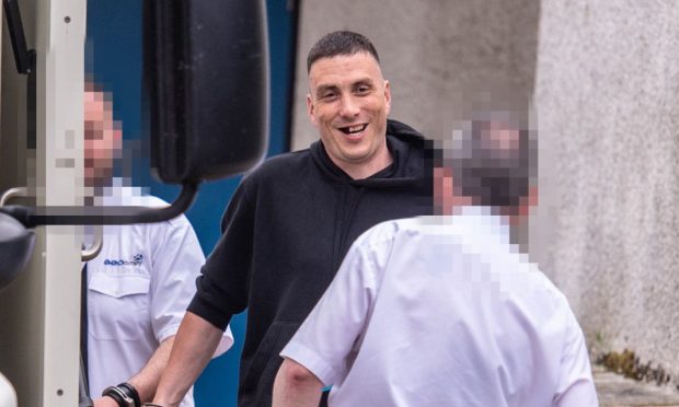 Aurimas Samalkis hid his face as he left Aberdeen Sheriff Court. Image: DC Thomson