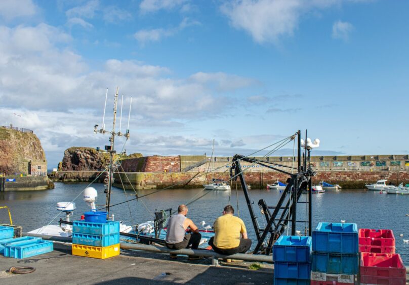 Fishermen sitting on the quayside. 