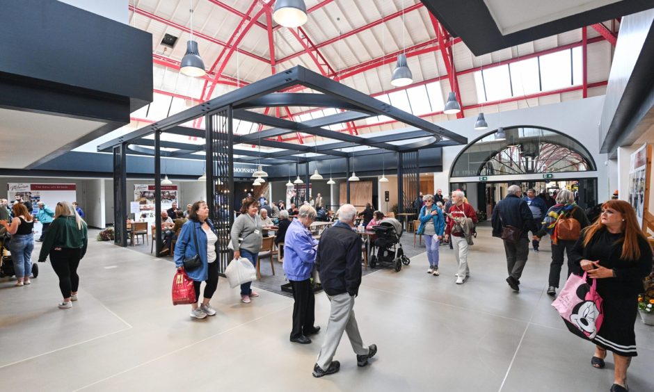 People gather to eat and shop in the market's food hall.