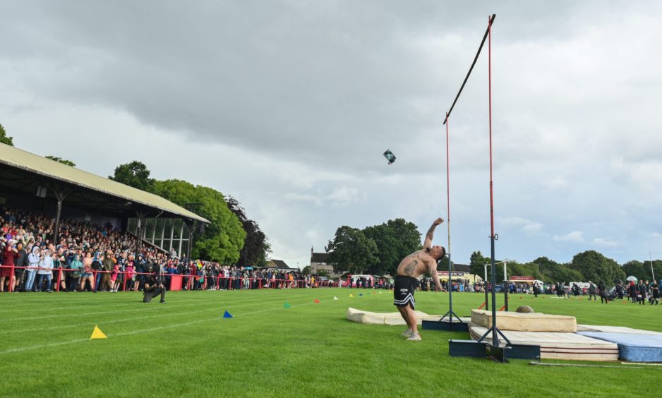 A man throwing the weight over the bar