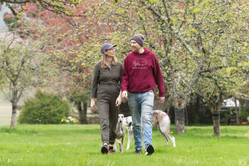 Holly and James walking in garden with dogs 