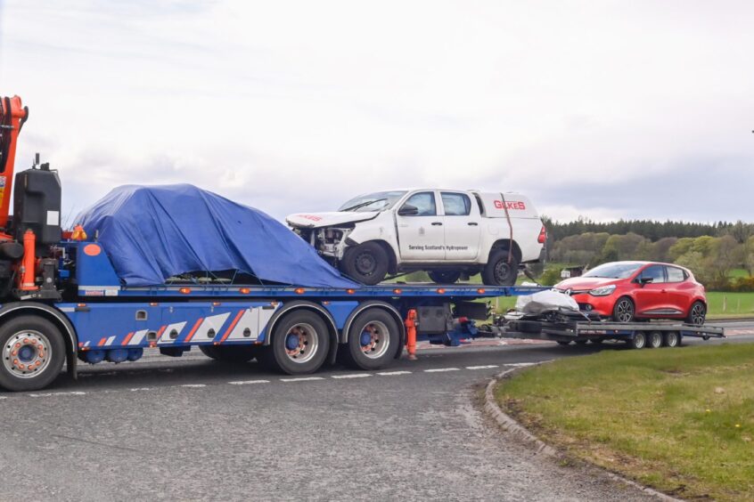 A black Mini Cooper, a white Toyota Hilux and a red Renaut Clio were loaded on to a recovery lorry 