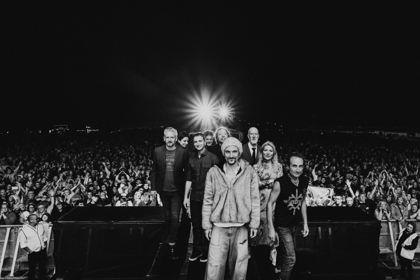 Manchester legends James on stage with a crowd of fans behind them