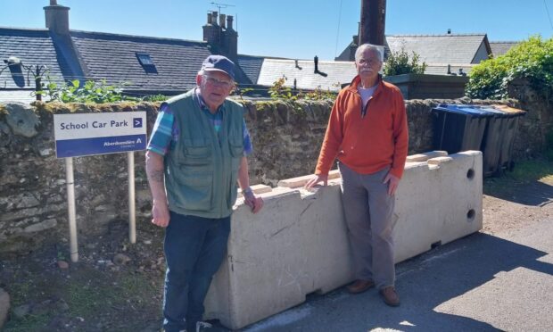 Don Marr and Michael Bennett stand next to the concrete roadblock. Image: Kirstie Topp/DC Thomson