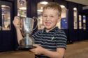 Murdo Davidson, aged 4, collects the trophy for best bullock on the hoof. Pictures by Kenny Elrick/DC Thomson