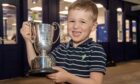 Murdo Davidson, aged 4, collects the trophy for best bullock on the hoof. Pictures by Kenny Elrick/DC Thomson