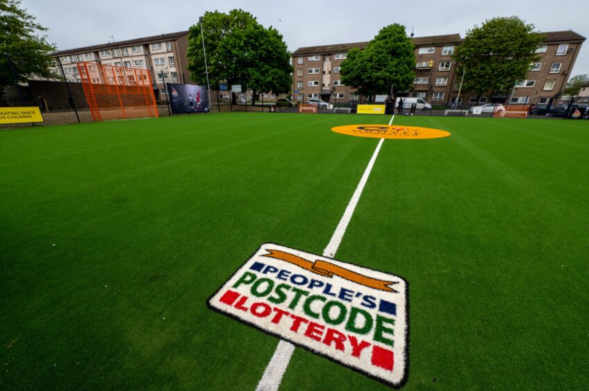 Artifical sports court complete with square Postcode Lottery logo.