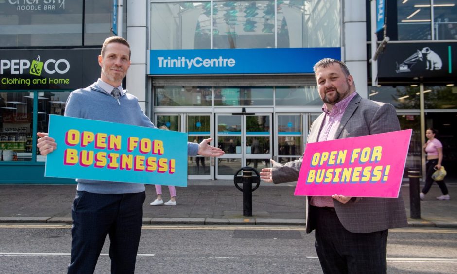 Trinity Centre's commercial manager Colin Thomson and centre manager Kebby Bruce holding signs for the "open for business" campaign.