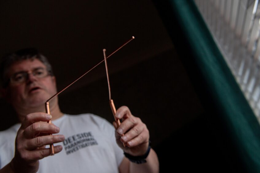 Ian Pennington holding dowsing rods 