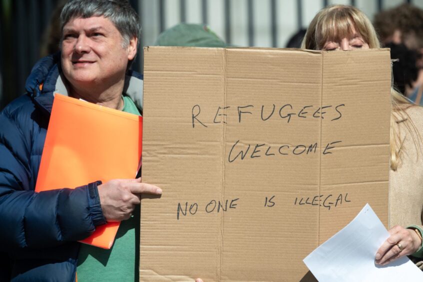 People holding a "refugees welcome" sign
