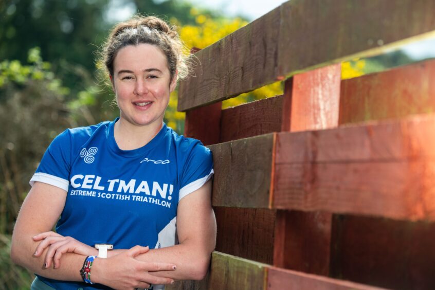 Eilidh leaning against a wooden fence