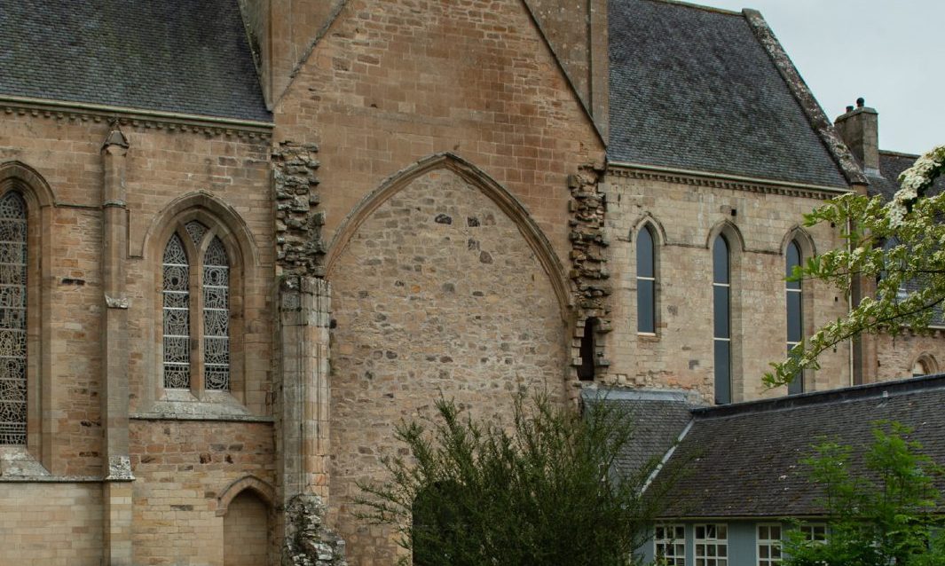 Exterior of Pluscarden Abbey with broken stonework. 