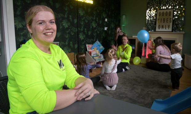 Leanne Shand in Fika playroom with children and staff behind.