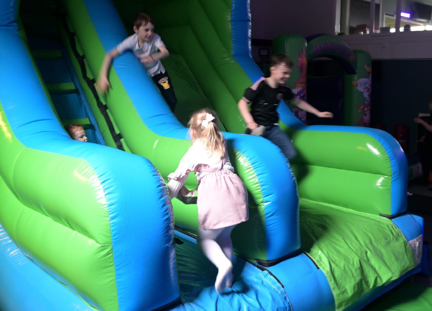 Children on inflatable slide inside Fika. 