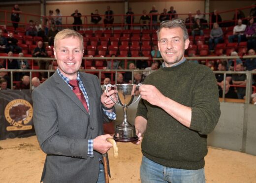 Luing cattle judge Euan Ferguson (left) presents the champions trophy to Rory Cameron of Monzie, Blair Atholl. Pictures by Sandy McCook/DC Thomson.