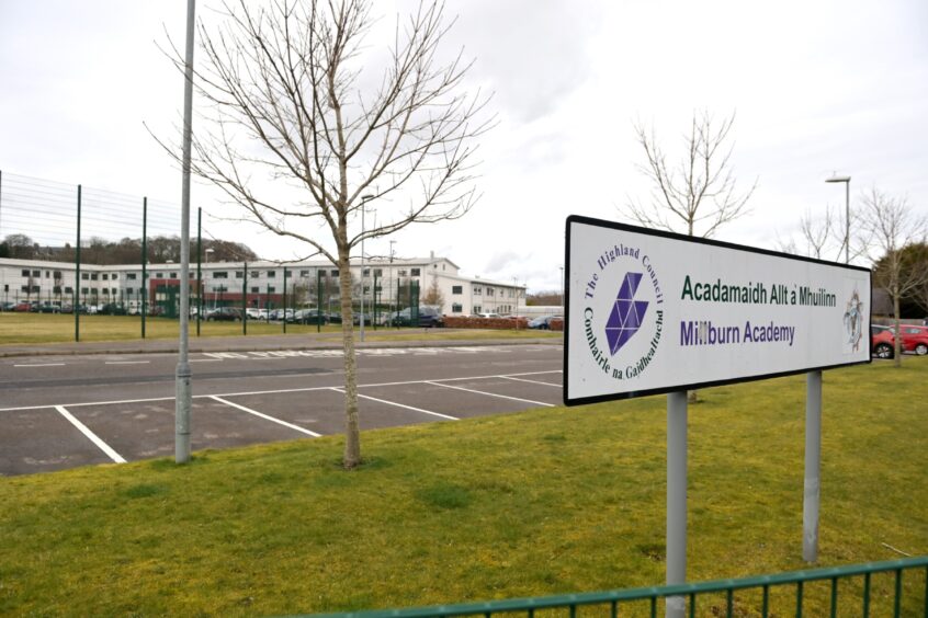 A general view of Millburn Academy, a modern secondary in Inverness, with the school sign in the foreground.