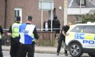 Blurred image of man leaving house with police