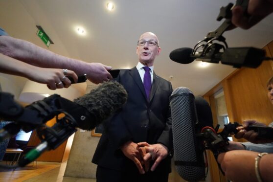 First Minister John Swinney arrives to speak to the media in the Scottish Parliament at Holyrood, Edinburgh. Image: PA