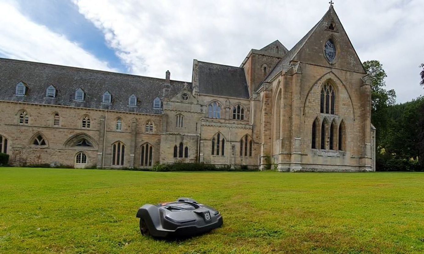 Lawnmower with Pluscarden Abbey behind. 