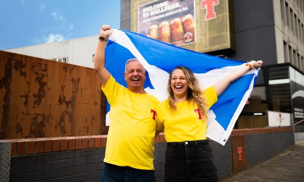 William Wallace and Beth Wallace holding a Scotland flag.