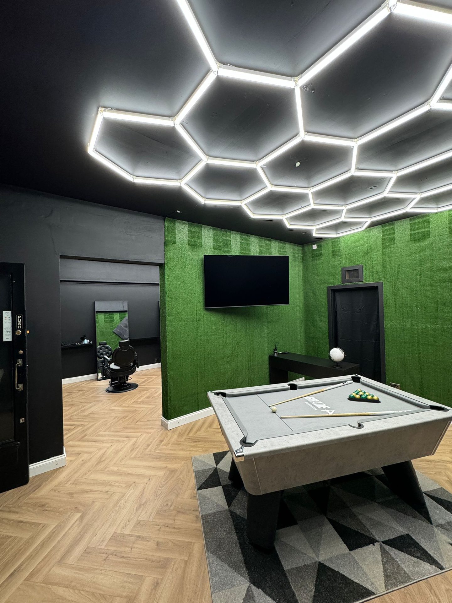 Interior of Grade A Barbers in Aberdeen with green walls and pool table