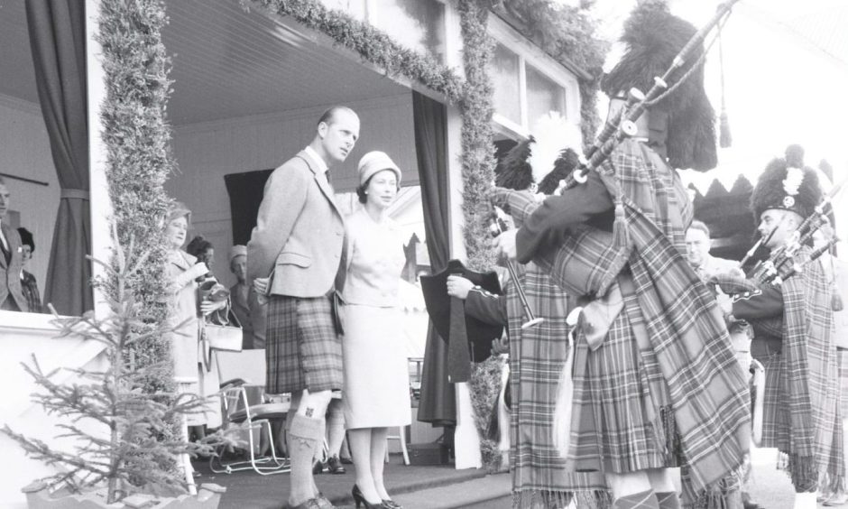 The Royal Family attending the Braemar Gathering with pipers playing bagpipes