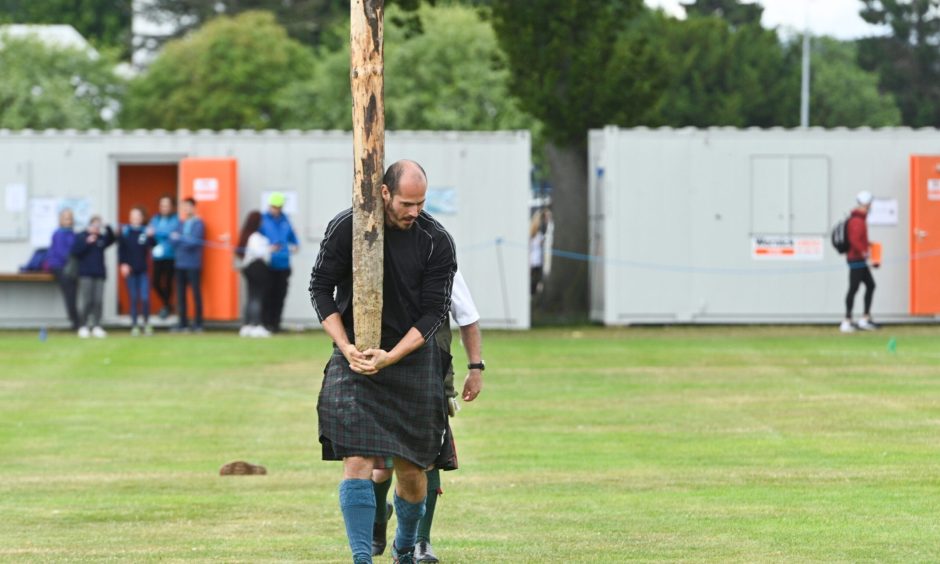 A man tossing the caber at Inverness Highland Games