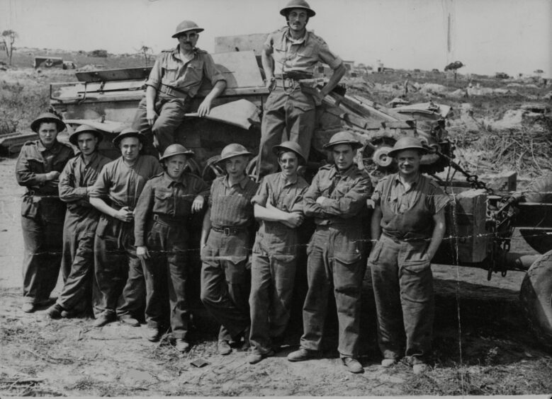 REME troops stand around a tank during the invasion of Italy.