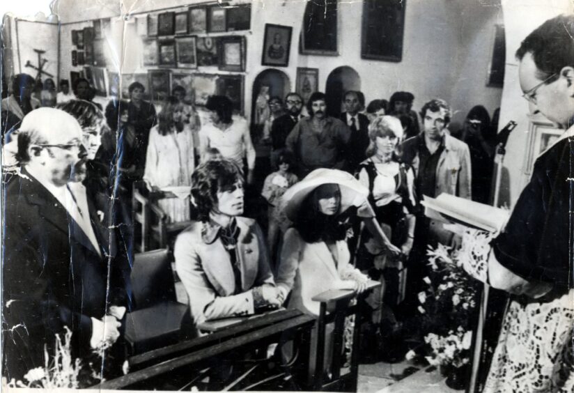 Mick Jagger and Bianca kneel at the altar during the wedding ceremony.