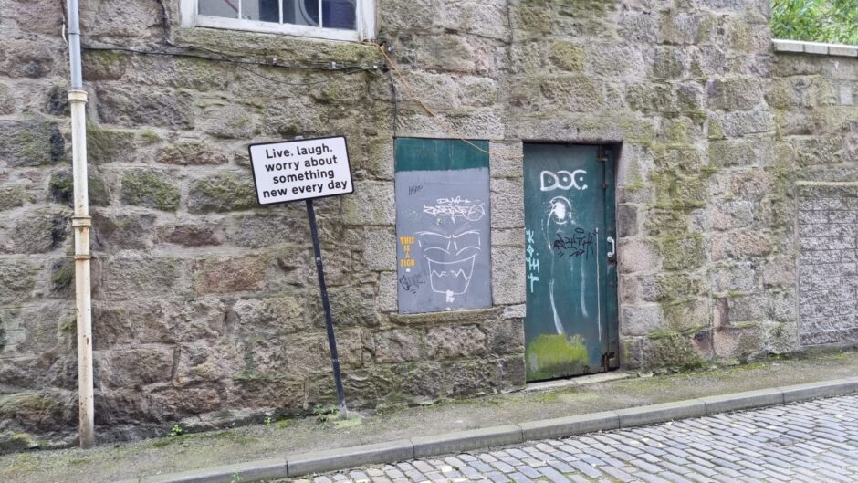 Sign on Shore Lane near the harbour, reads: "Live. Laugh. Worry about something new every day."