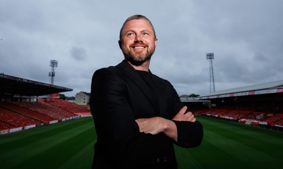 Aberdeen manager Jimmy Thelin pictured at Pittodrie stadium with the pitch and Red Shed behind him.