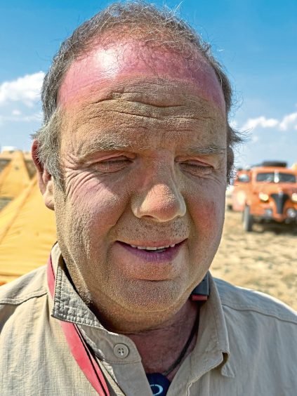 Mike Sinclair, covered in sand after their daring drive through the desert.