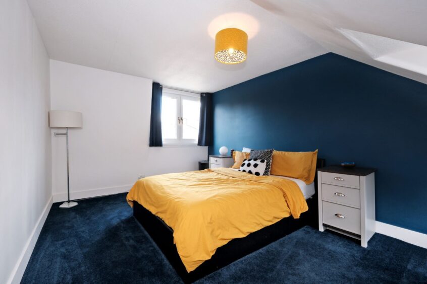 The navy and yellow bedroom in the fittie home