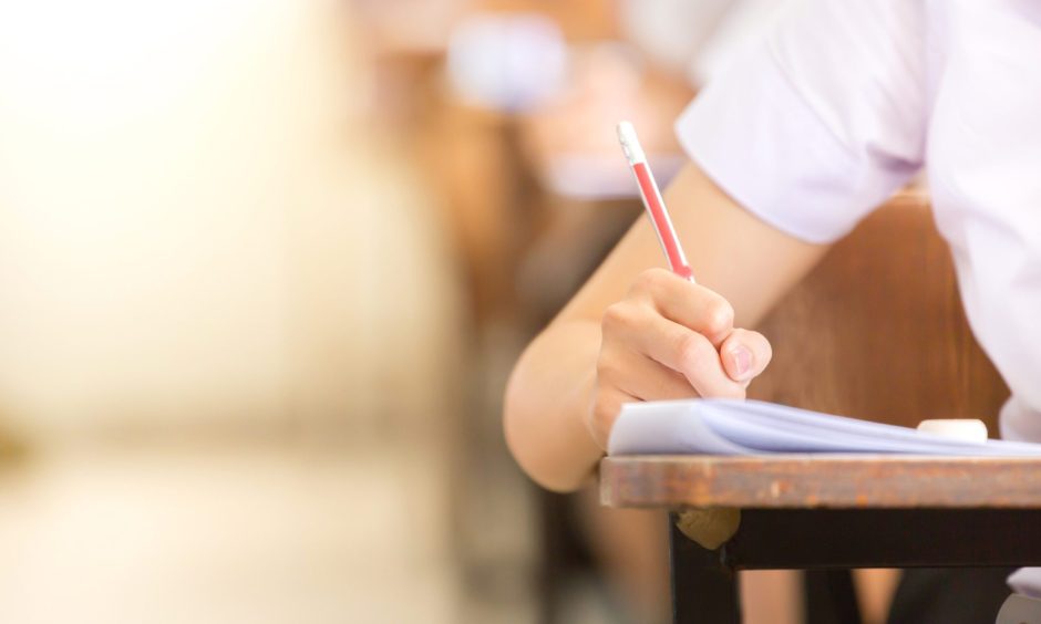 Stock image of child writing at desk. 