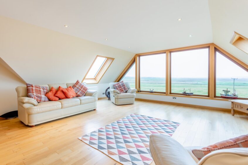 Spacious sitting room in the Highland house for sale, featuring large windows and beautiful views over the Morven hills