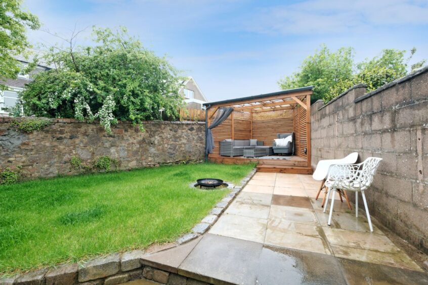 The garden after the Aberdeen home makeover, with a shelter decking area, a section of grass and a firepit