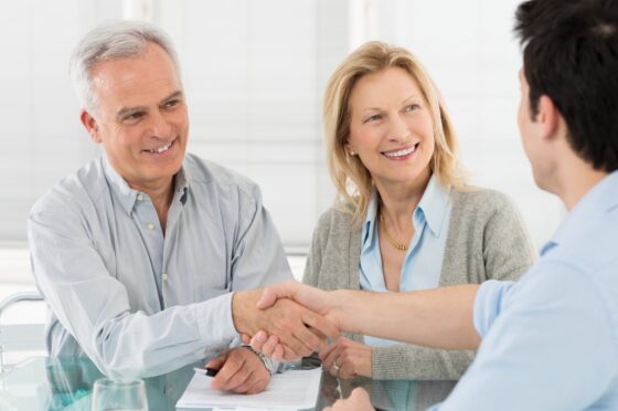 Senior Happy Couple Shaking Hands With Financial Advisor