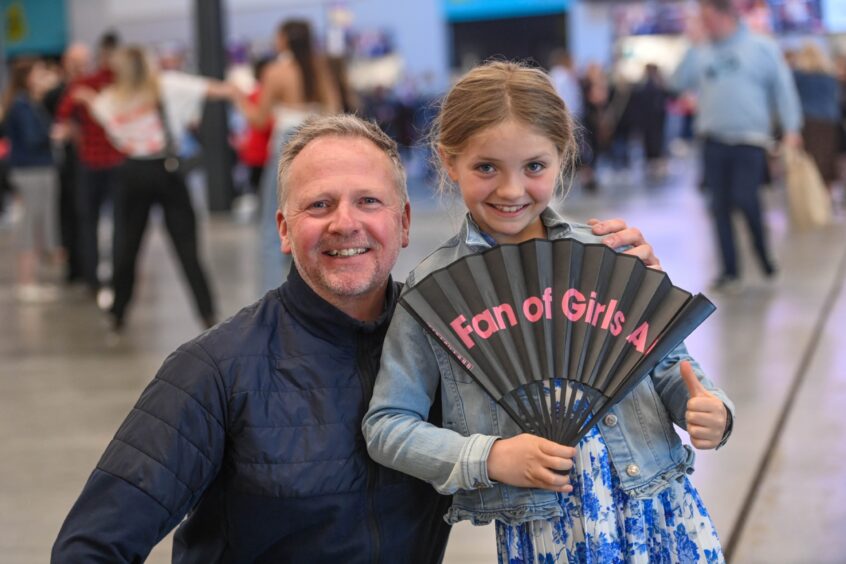 Young girl pictured holding a hand fan ahead of the Girls Aloud concert at Aberdeen's P&J Live