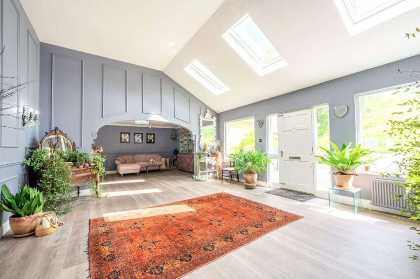 Large entrance hall flooded with natural light with whit and light blue walls.