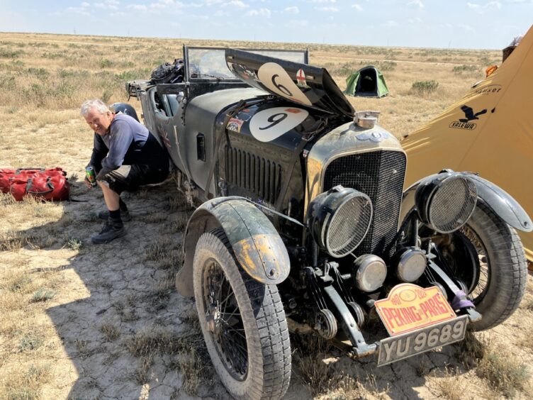 Driver Andy Buchan with 'Crunchie', camping in Kazakhstan during the Peking to Paris vintage rally race.