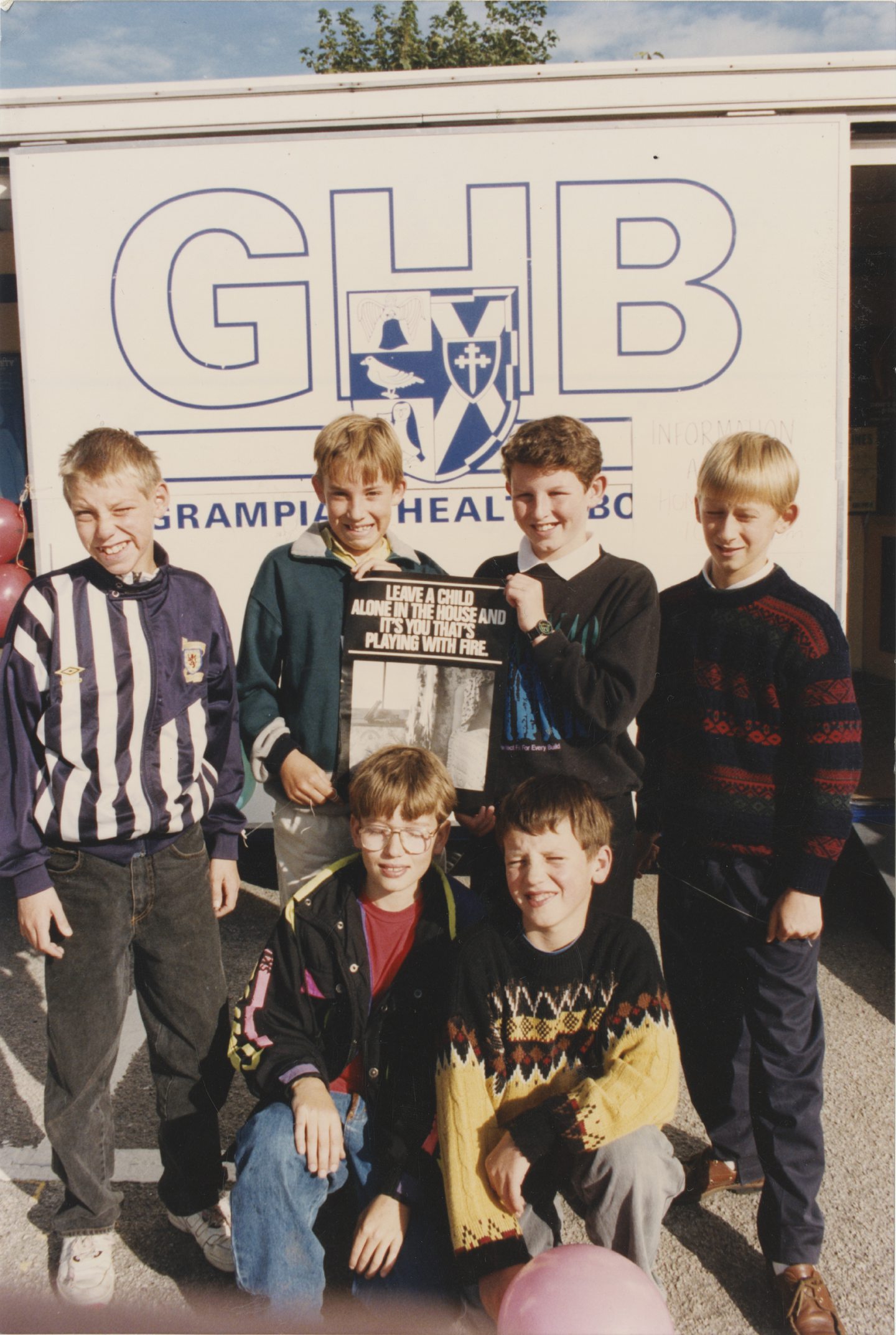 A group of six pupils holding a safety poster