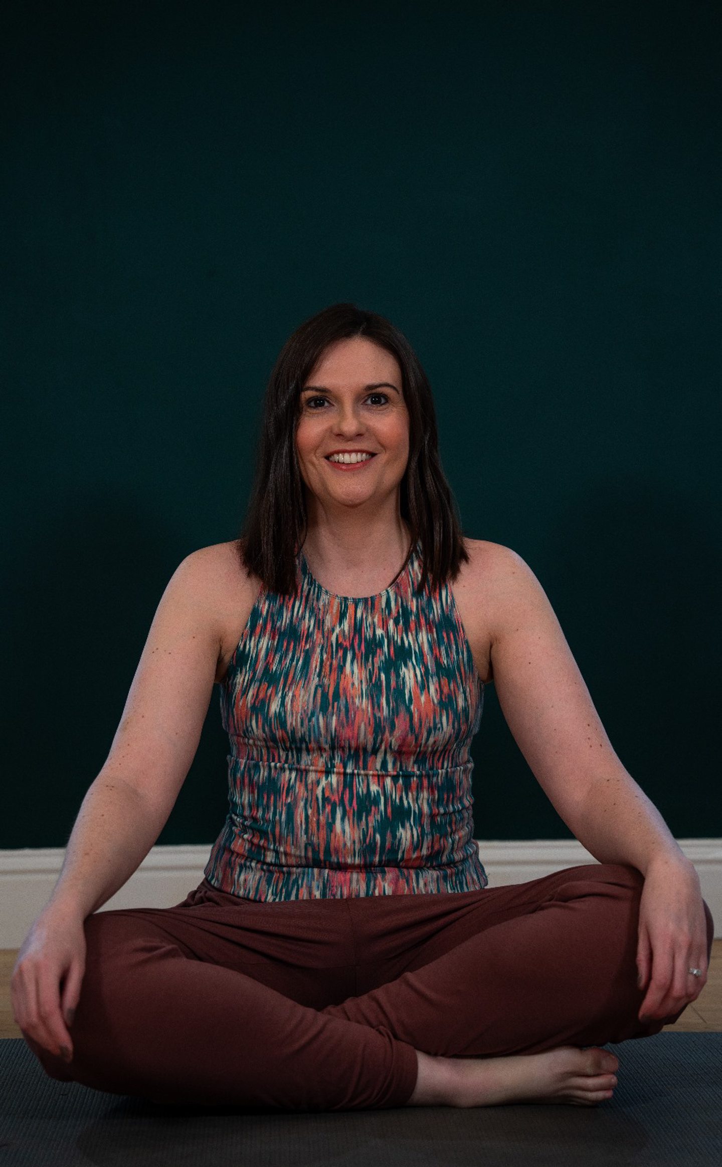 The Aberdeen pregnancy pilates instructor sitting cross-legged.