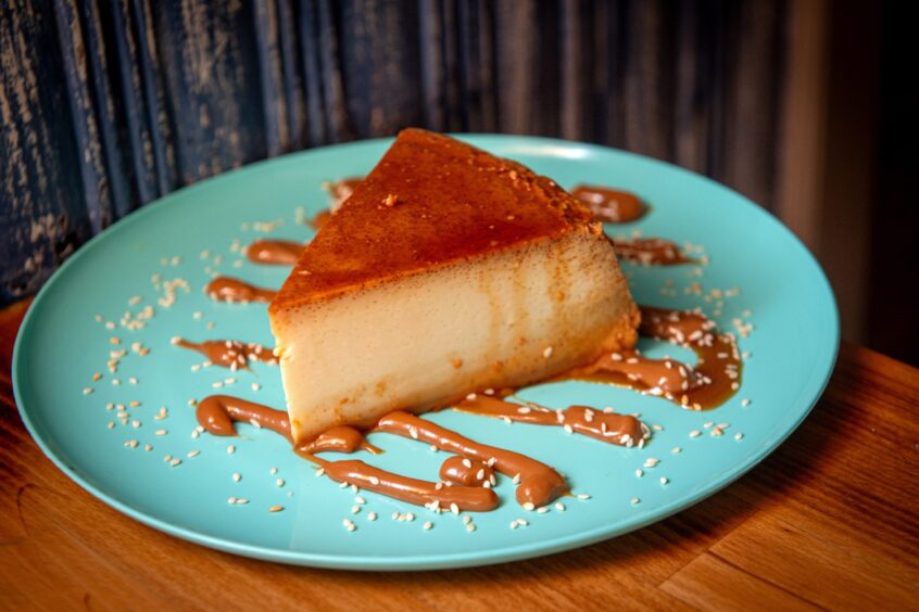 The quesillo (Venezuelan flan) on a bright blue plate.