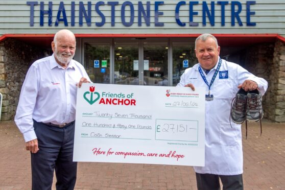 Auctioneer Colin Slessor presents the cheque to Jim Milne of Friends of Anchor. Picture by Kath Flannery/DC Thomson.